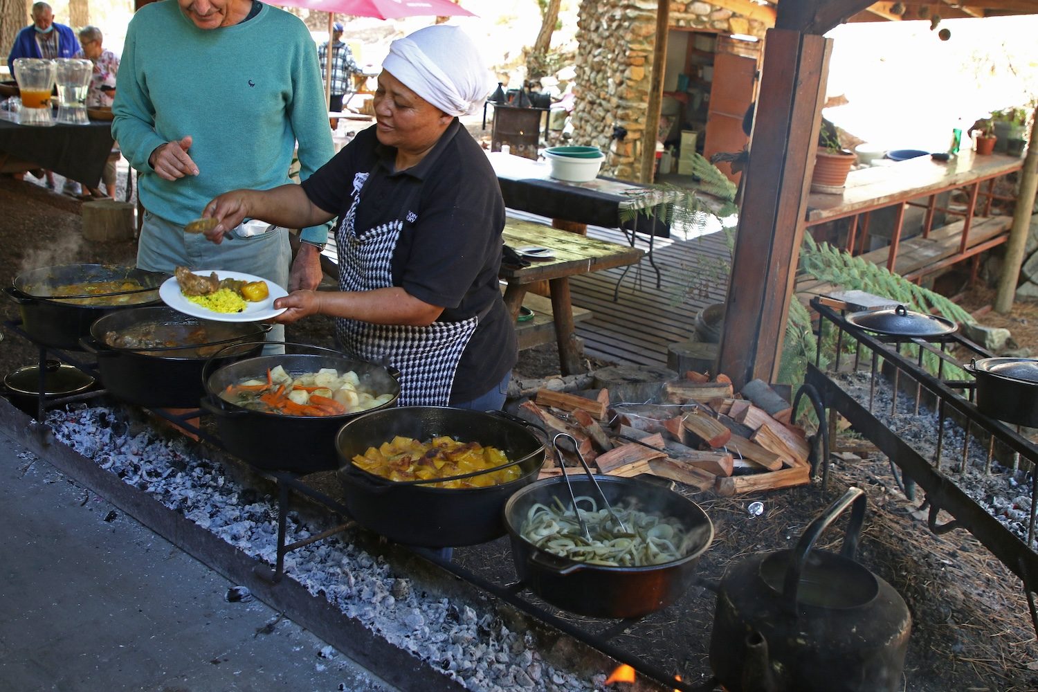 Serving from the potjies at the fire